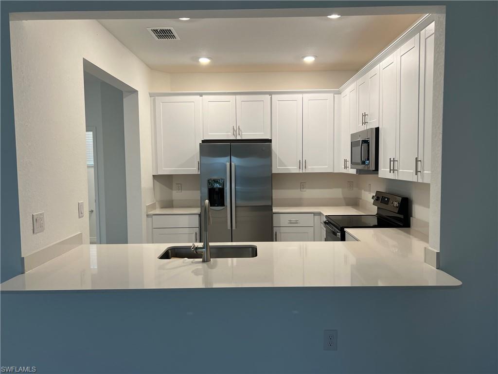 2971 Citrus Street Naples, FL 34120 - Photo 8 of 42 a kitchen with stainless steel appliances a refrigerator sink and stove