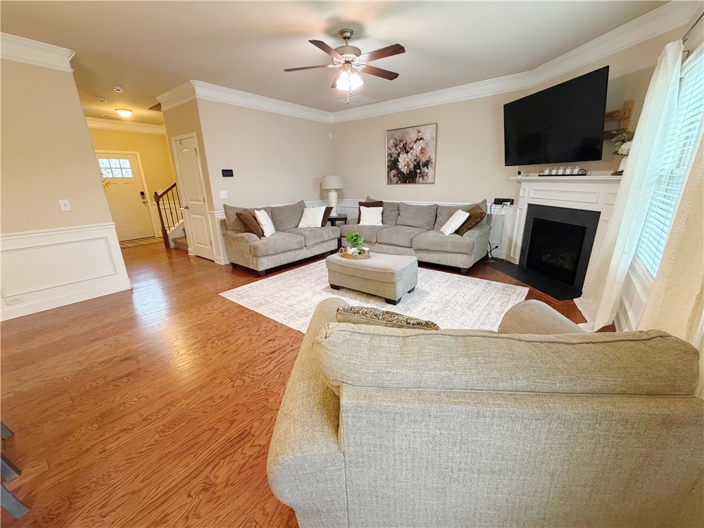 874 Wild Orchard Lane Woodruff, SC 29388 - Photo 4 of 12 This inviting living space features gleaming hardwood floors, a cozy fireplace, and elegant crown molding.