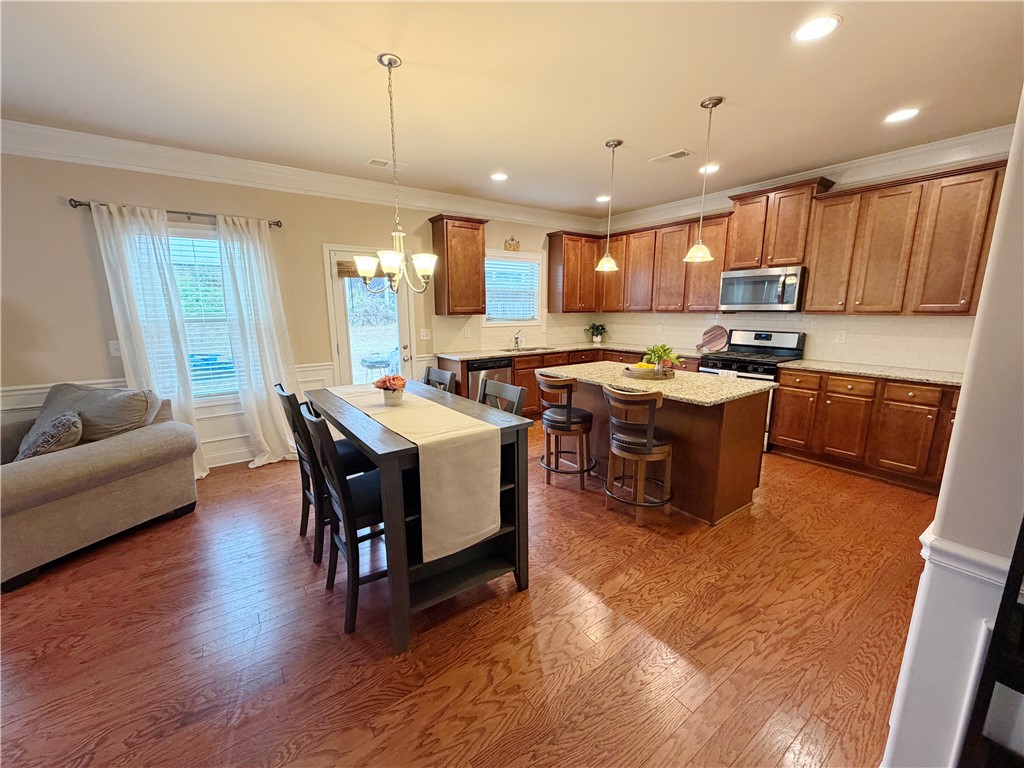 874 Wild Orchard Lane Woodruff, SC 29388 - Photo 6 of 12 This kitchen features hardwood floors, granite countertops, and stainless steel appliances.