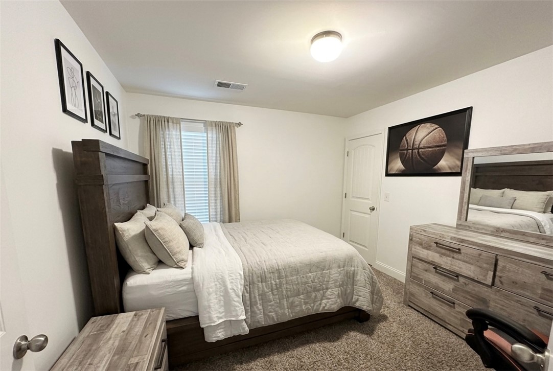 874 Wild Orchard Lane Woodruff, SC 29388 - Photo 10 of 12 This spacious bedroom offers a neutral palette, plush carpeting, and abundant natural light. Virtually staged room.