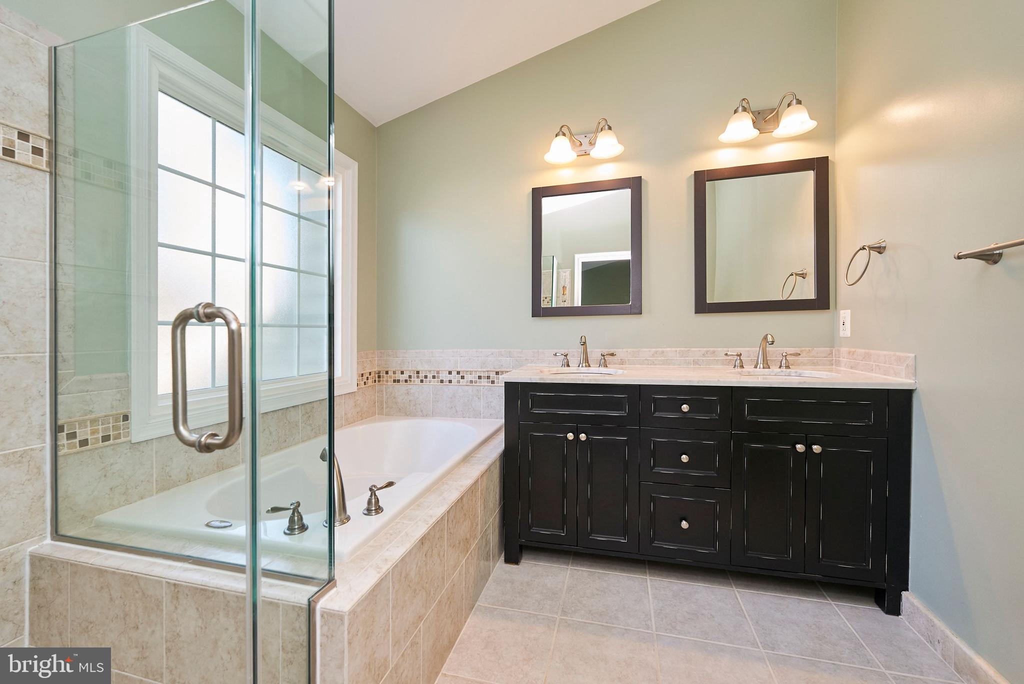 20340 Brentmeade Terrace Sterling, VA 20165 - Photo 15 of 43 a bathroom with a tub sink double vanity and mirror