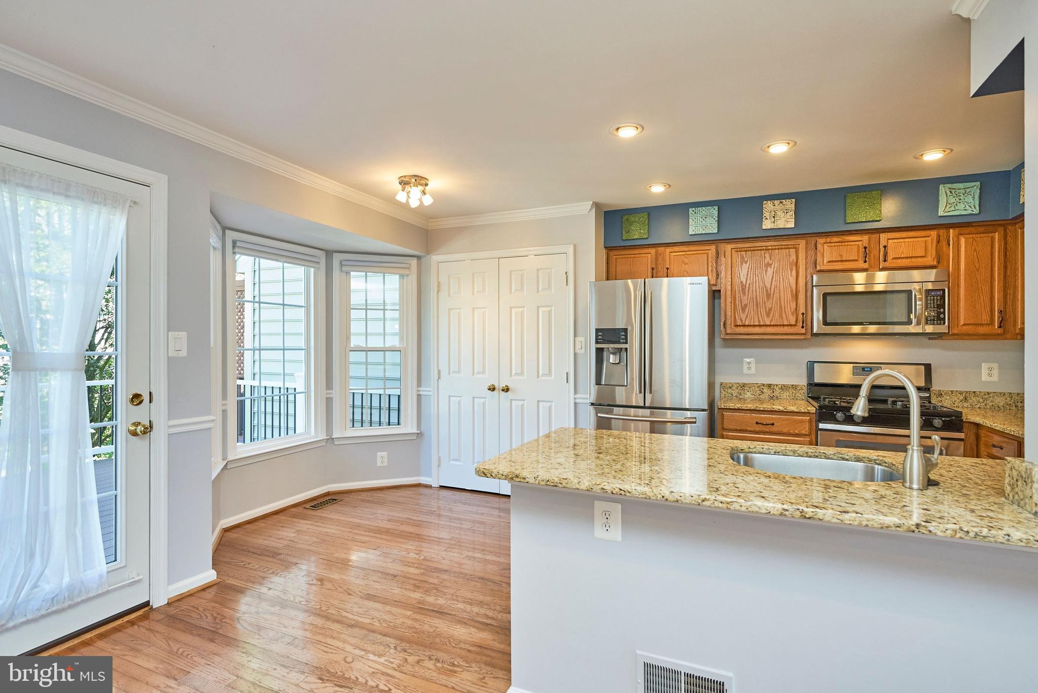 20340 Brentmeade Terrace Sterling, VA 20165 - Photo 3 of 43 a view of a kitchen with kitchen island a large window appliances and living room