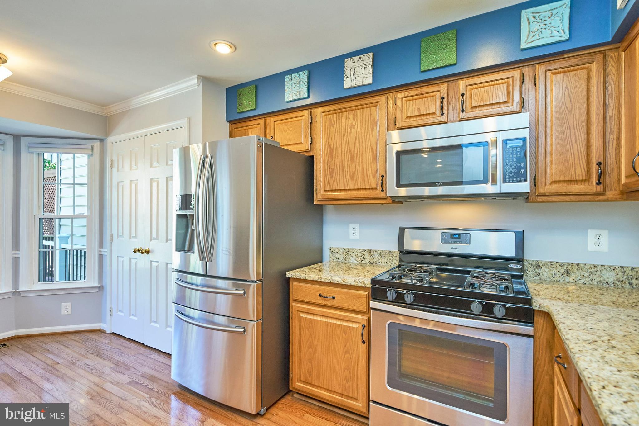 20340 Brentmeade Terrace Sterling, VA 20165 - Photo 4 of 43 a kitchen with stainless steel appliances granite countertop a refrigerator stove and microwave