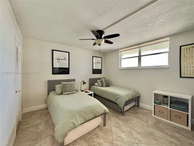 a bedroom with two beds and a desk