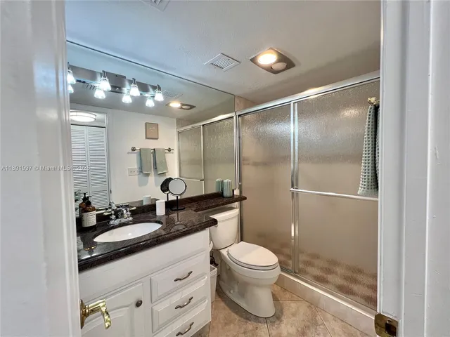 a bathroom with a double vanity sink toilet and shower