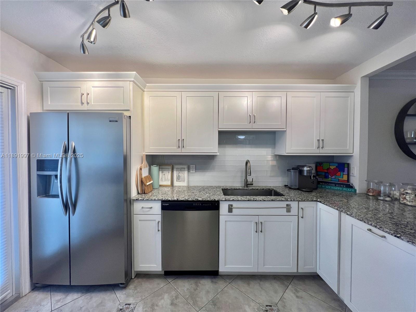 750 North Ocean Boulevard, Unit 905 Pompano Beach, FL 33062 - Photo 3 of 29 a kitchen with a refrigerator sink and cabinets