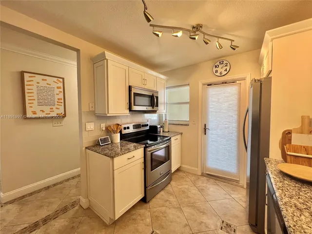 a kitchen with stainless steel appliances granite countertop a refrigerator a stove top oven a sink and dishwasher