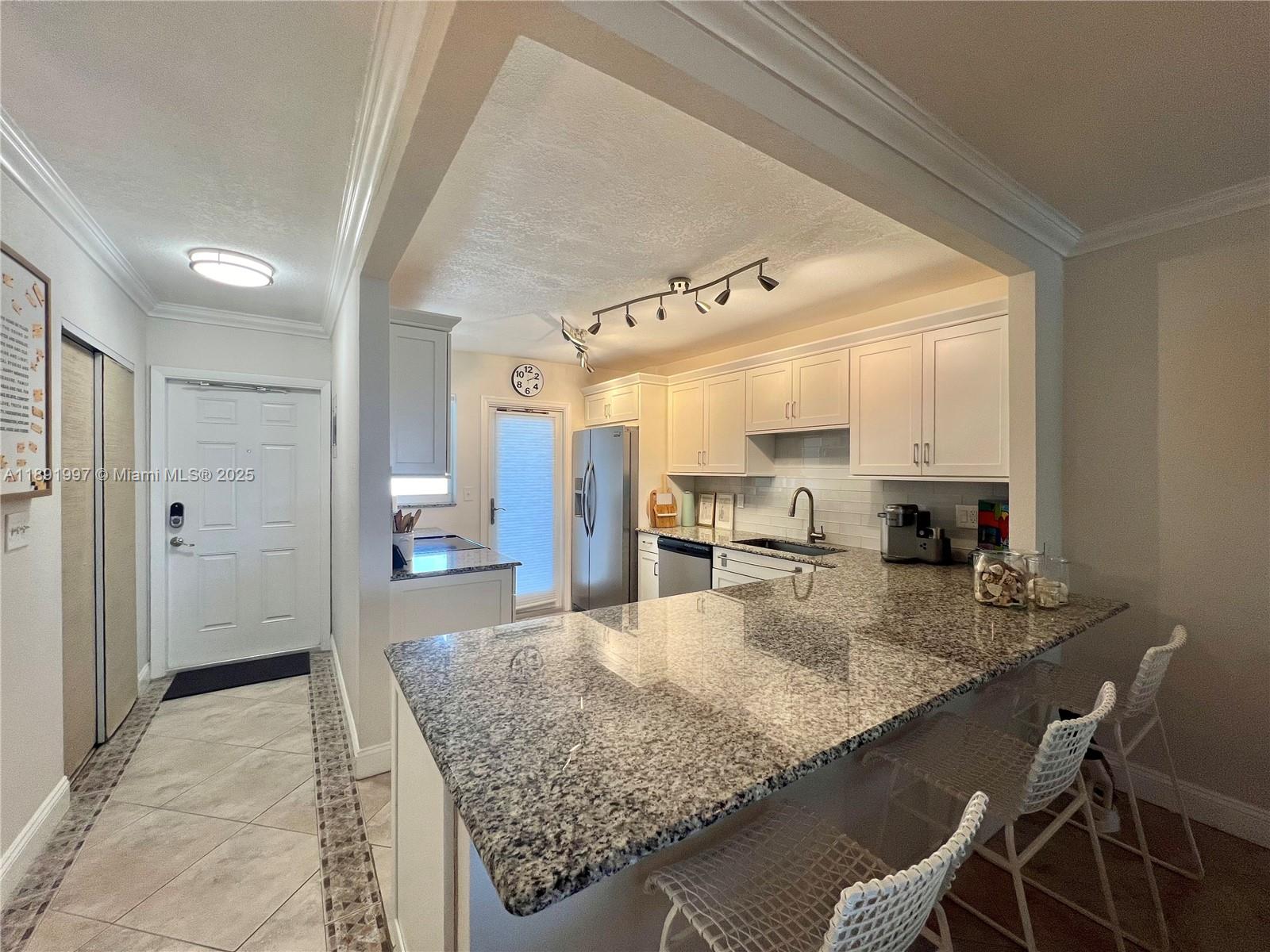 750 North Ocean Boulevard, Unit 905 Pompano Beach, FL 33062 - Photo 6 of 29 a kitchen with granite countertop lots of counter top space appliances and cabinets