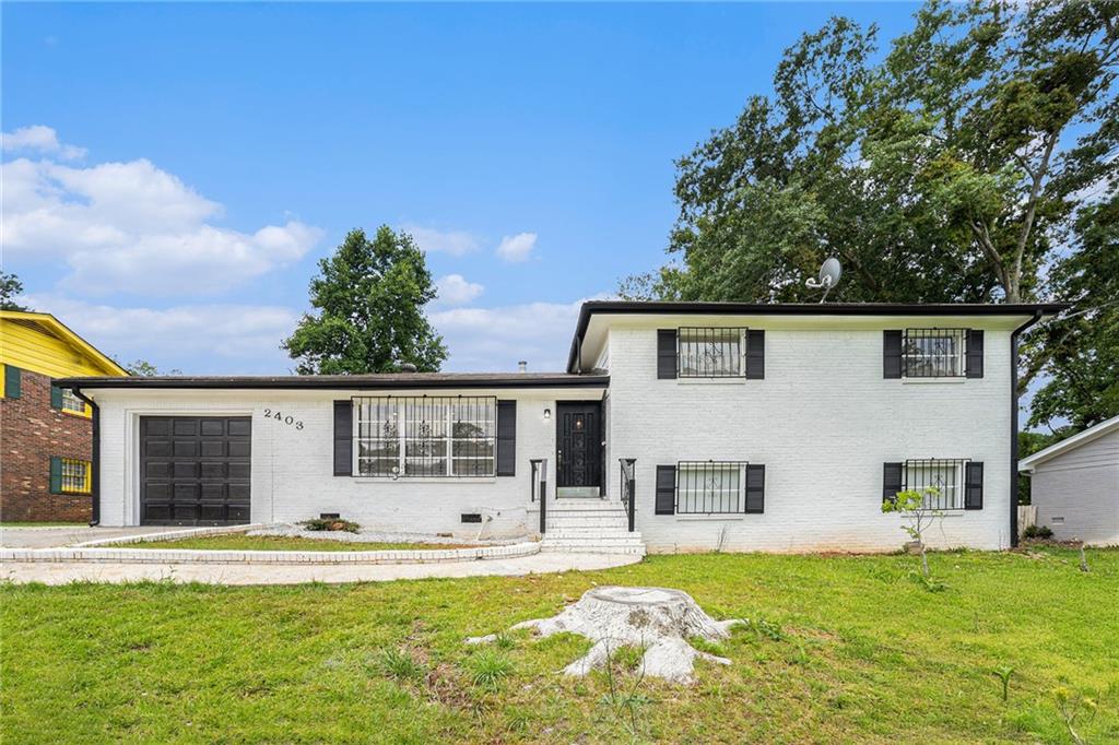 a view of a house with a swimming pool and a yard