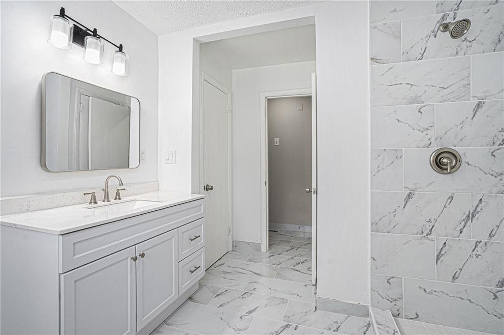 2403 Tiffany Place Decatur, GA 30035 - Photo 23 of 29 a bathroom with a granite countertop sink a mirror and a shower