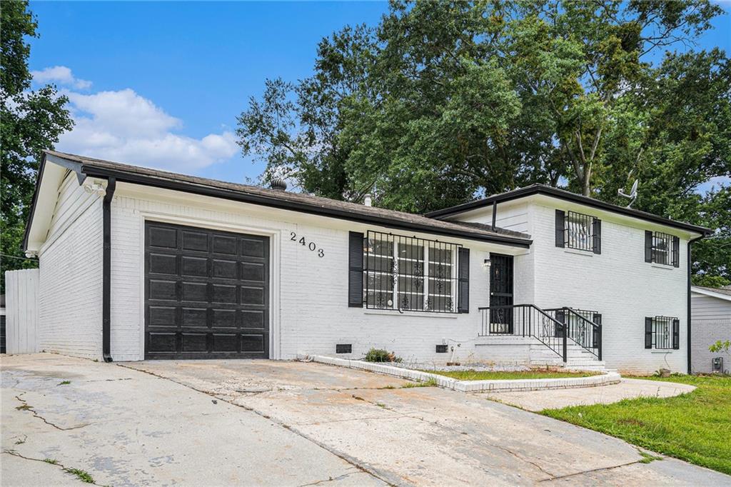 2403 Tiffany Place Decatur, GA 30035 - Photo 3 of 29 a front view of a house with a yard and garage