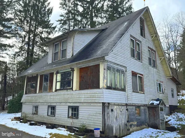 a front view of a house with a tree