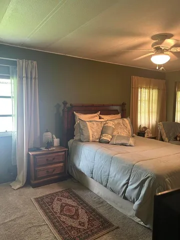 a bedroom with a bed a dresser and a flat screen tv