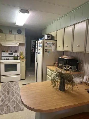 a kitchen with stainless steel appliances granite countertop a sink a stove and a refrigerator