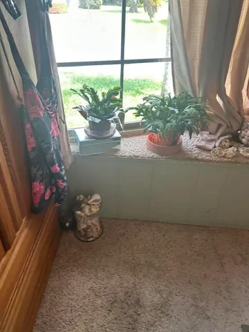 a vase of flowers sitting on a floor next to a window
