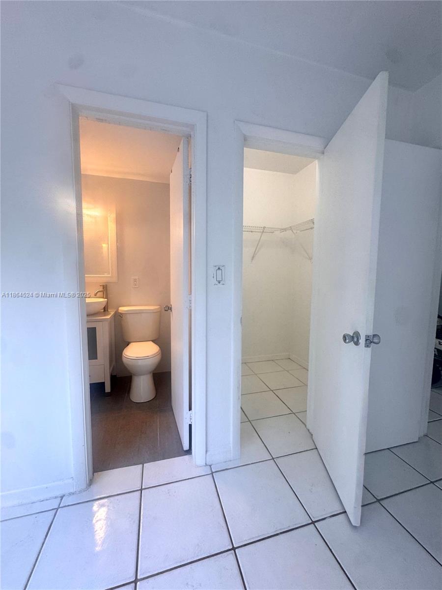 6310 Southwest 79th Street, Unit 2 South Miami, FL 33143 - Photo 7 of 8 a spacious bathroom with a toilet a sink and mirror