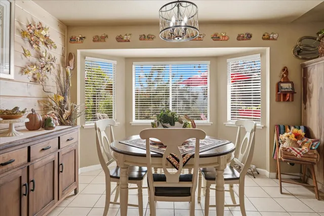 a kitchen with stainless steel appliances kitchen island granite countertop a stove a sink dishwasher and a dining table with wooden floor