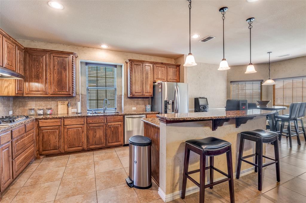 1512 Ruffian Road DeSoto, TX 75115 - Photo 7 of 25 a kitchen with sink cabinets and dining table