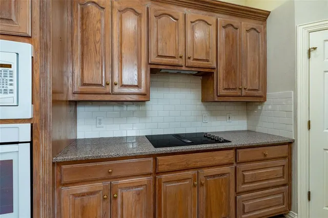 a kitchen with granite countertop cabinets and black appliances