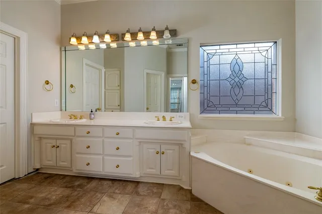 a bathroom with a double vanity sink large mirror and a bathtub