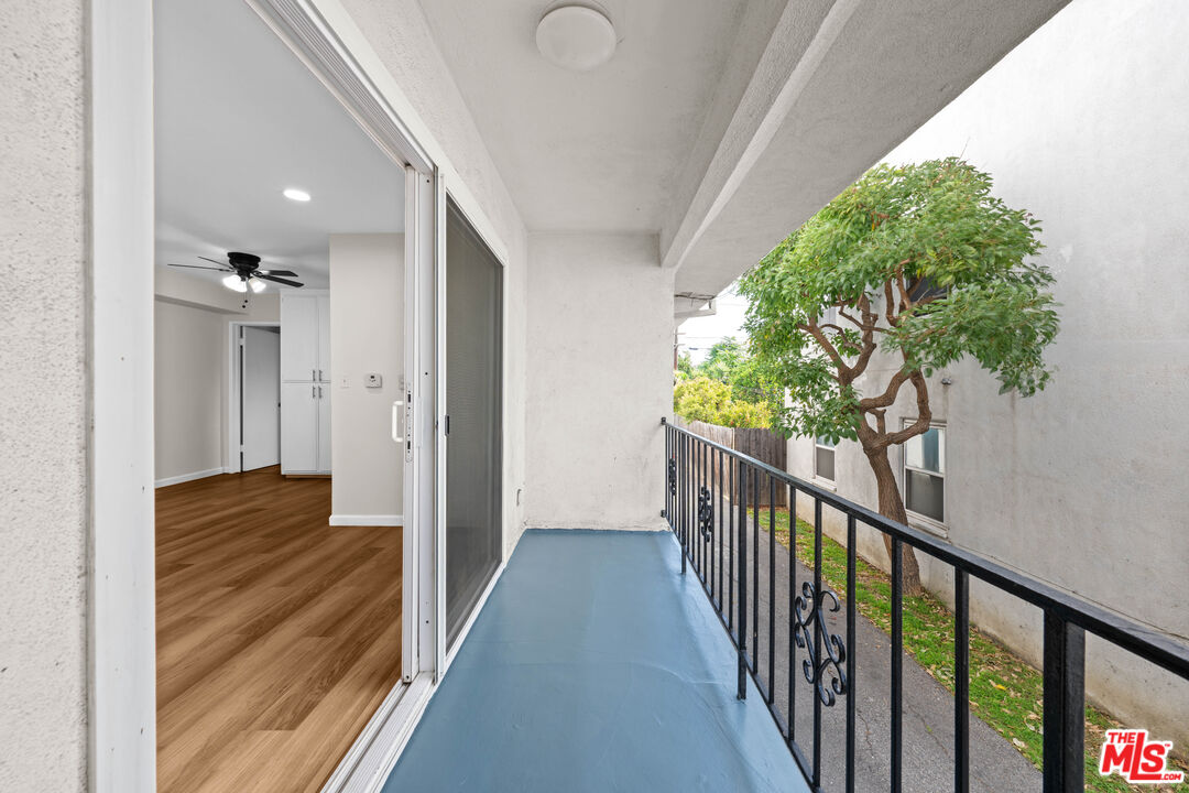 1206 South Holt Avenue, Unit 2 Los Angeles, CA 90035 - Photo 15 of 17 a view of a hallway to a livingroom with wooden floor and stairs