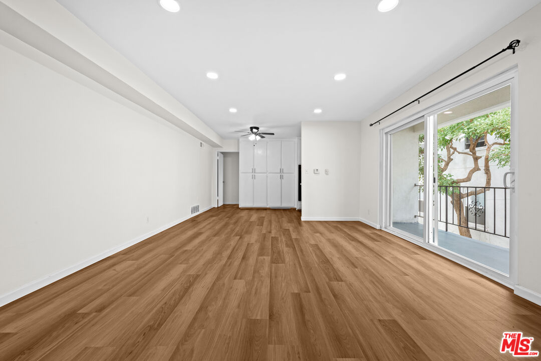 1206 South Holt Avenue, Unit 2 Los Angeles, CA 90035 - Photo 3 of 17 a view of empty room with wooden floor and fan