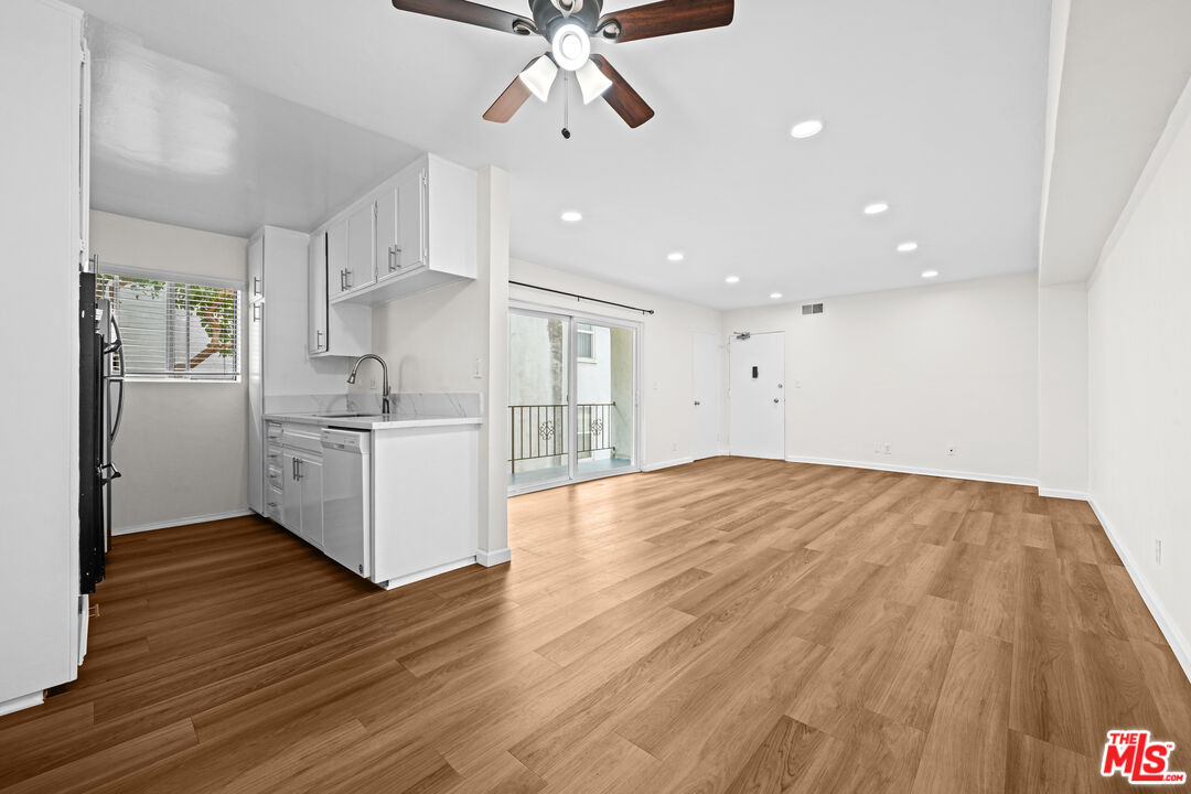 1206 South Holt Avenue, Unit 2 Los Angeles, CA 90035 - Photo 5 of 17 a view of a kitchen with wooden floor and a ceiling fan
