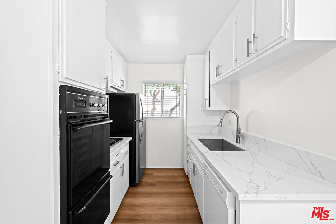 1206 South Holt Avenue, Unit 2 Los Angeles, CA 90035 - Photo 6 of 17 a kitchen with stainless steel appliances granite countertop a refrigerator and a sink