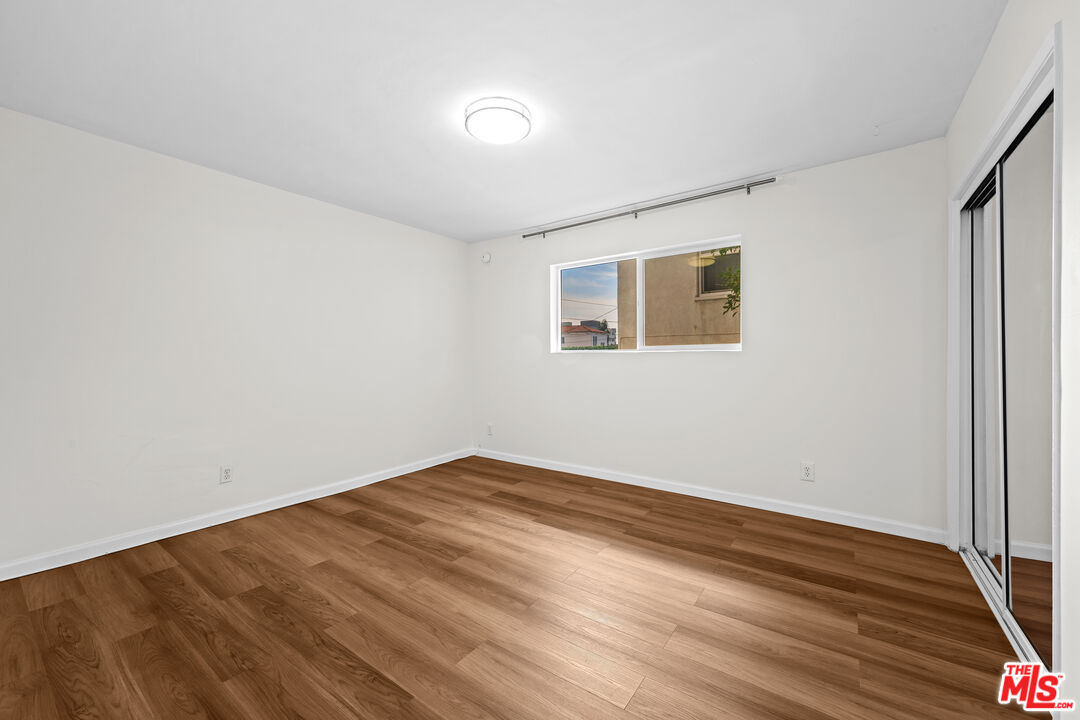 1206 South Holt Avenue, Unit 2 Los Angeles, CA 90035 - Photo 8 of 17 an empty room with wooden floor and windows