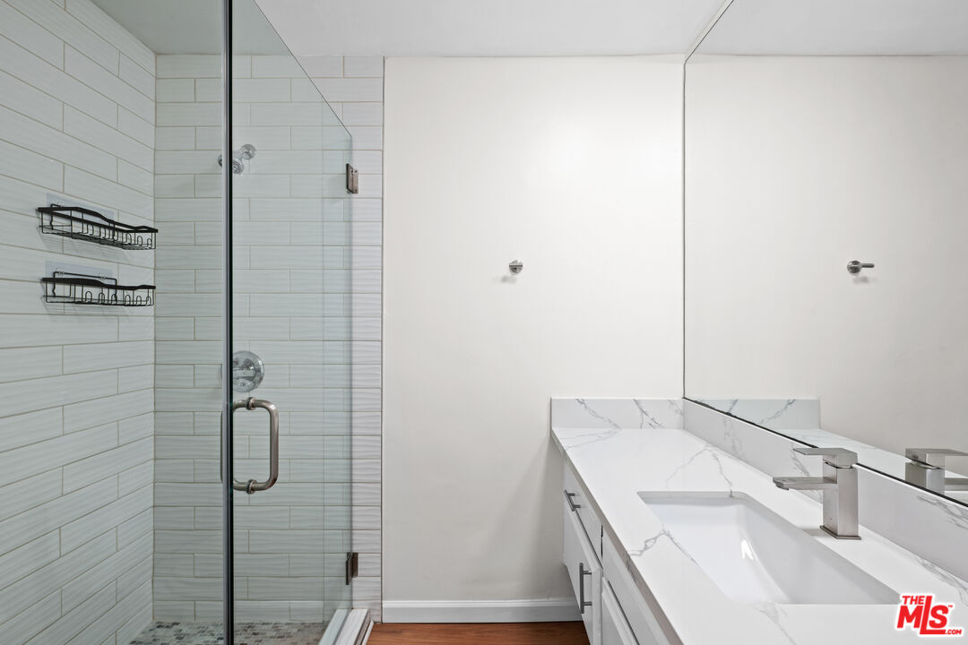 1206 South Holt Avenue, Unit 2 Los Angeles, CA 90035 - Photo 10 of 17 a bathroom with a granite countertop shower sink and vanity