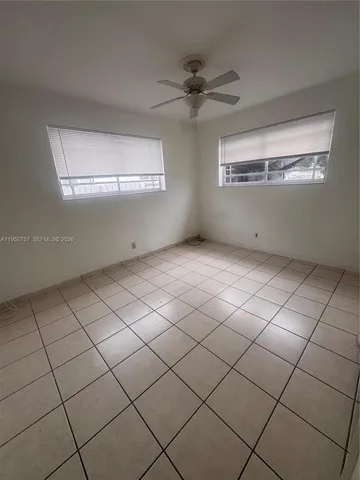 a view of an empty room and a ceiling fan