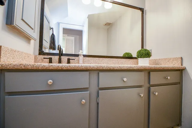 a bathroom with a granite countertop sink and mirror