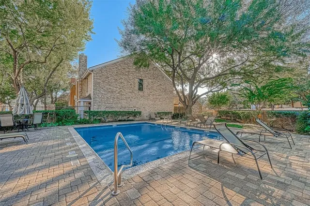 a view of backyard with swimming pool and seating space