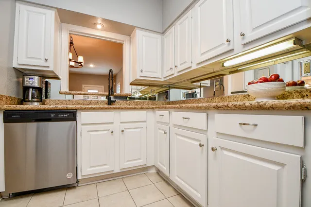 a kitchen with granite countertop white cabinets and white appliances