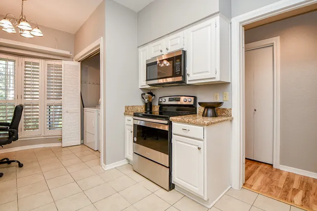 a kitchen with stainless steel appliances granite countertop a stove a microwave and a refrigerator