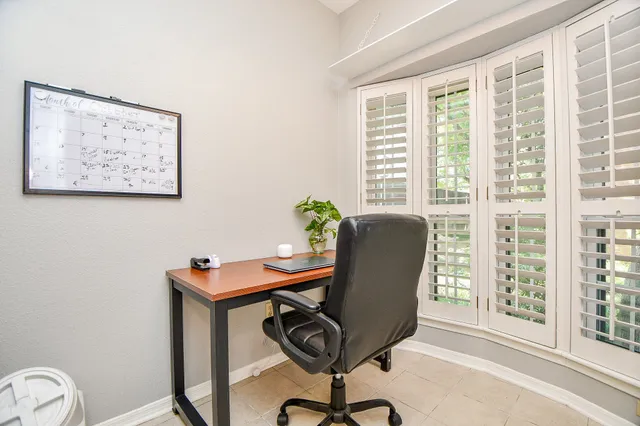 a view of a workspace with furniture and a window