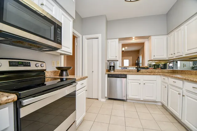 a kitchen with a stove and white cabinets