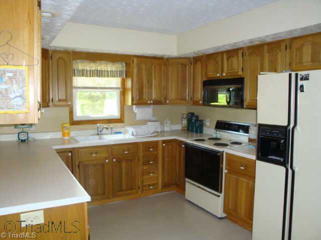 121 Pete Foster Road Mocksville, NC 27028 - Photo 2 of 9 Other. Kitchen with appliances to remain, Lots of cabinets, View to Backyard, Updated Flooring, Bar Top Area for Bar Stools looking into Dining Area