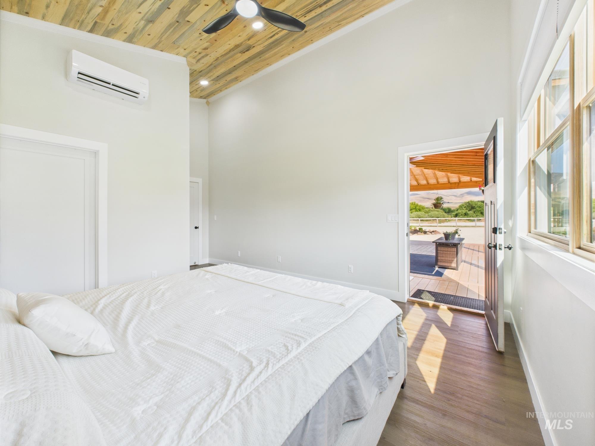 6501 Sweet Ola Highway Sweet, ID 83670 - Photo 17 of 43 Bedroom featuring wooden ceiling, dark wood-style floors, a high ceiling, a wall mounted air conditioner, and ceiling fan