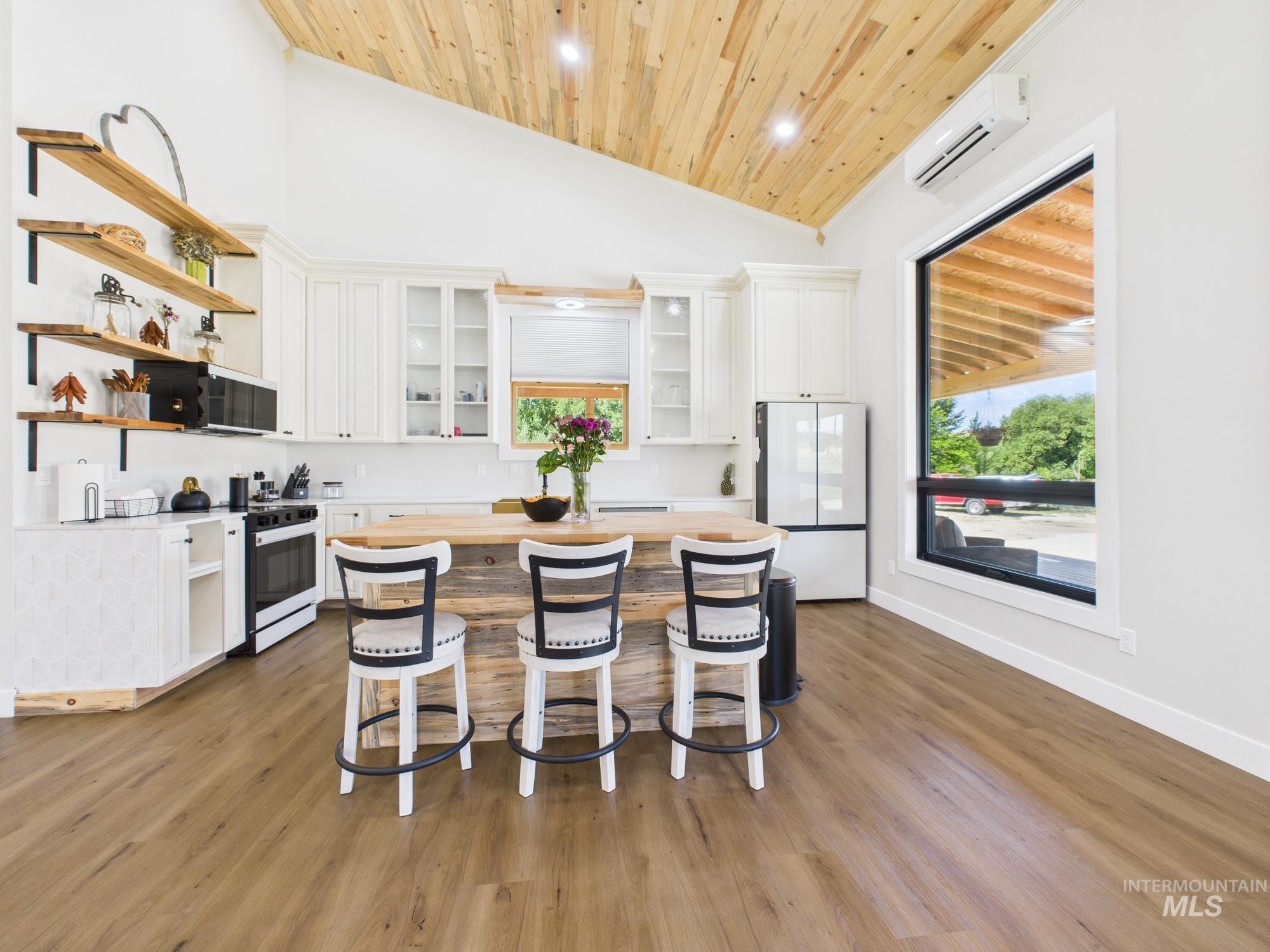6501 Sweet Ola Highway Sweet, ID 83670 - Photo 5 of 43 Kitchen featuring open shelves, wooden ceiling, white cabinetry, a breakfast bar, and white appliances