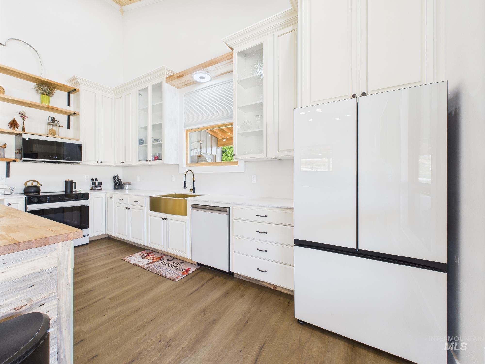 6501 Sweet Ola Highway Sweet, ID 83670 - Photo 7 of 43 Kitchen with open shelves, white appliances, wooden counters, light wood-style flooring, and white cabinets