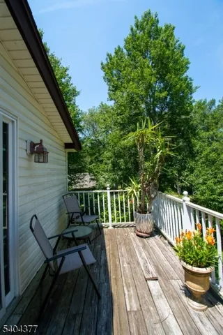 a view of a house with a deck and furniture