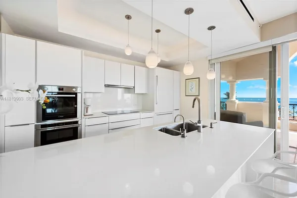 a kitchen with kitchen island a counter top space a sink stainless steel appliances and cabinets