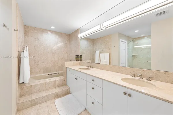 a spacious bathroom with a granite countertop sink mirror and shower