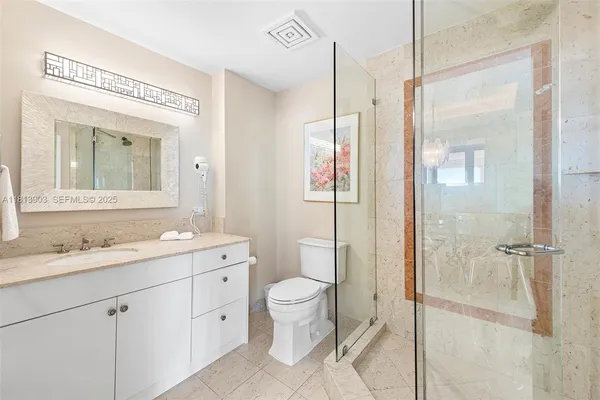 a spacious bathroom with a granite countertop sink a toilet and a mirror