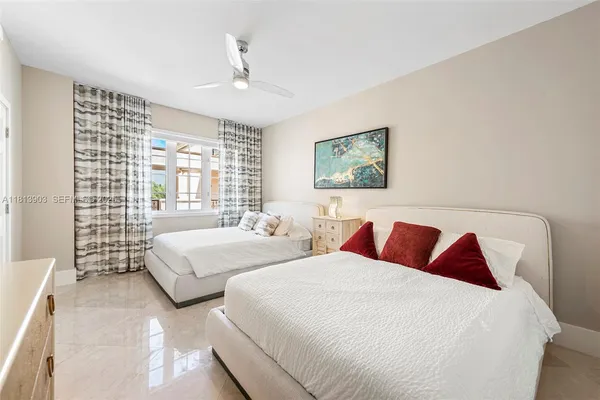 a bedroom with two beds and a large window