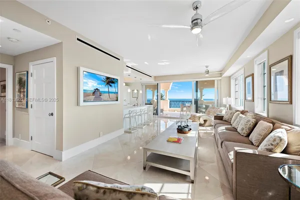 a living room with furniture kitchen view and a window