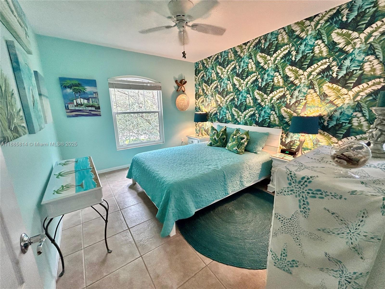 5080 Fairways Circle, Unit 307 Vero Beach, FL 32967 - Photo 15 of 27 a bedroom with a bed a mirror on dresser and a chandelier