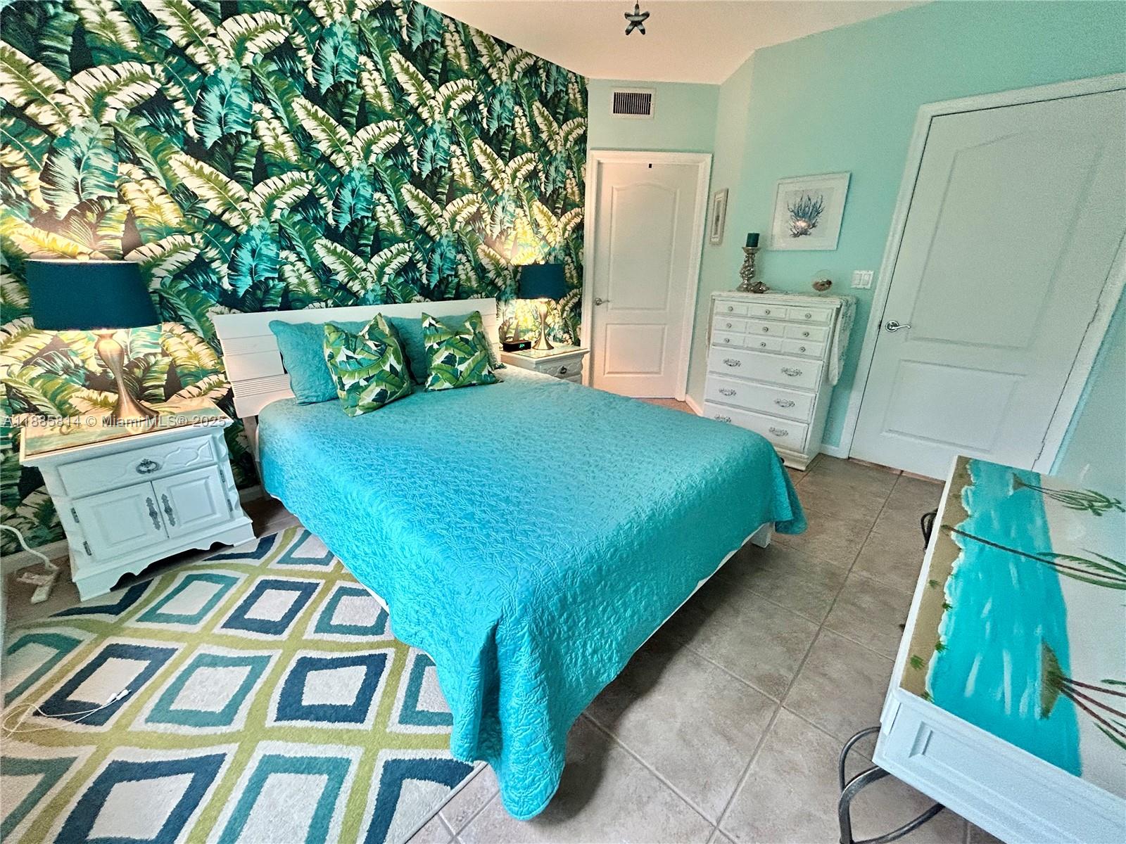 5080 Fairways Circle, Unit 307 Vero Beach, FL 32967 - Photo 16 of 27 a bed sitting in a bedroom next to a wooden cabinet