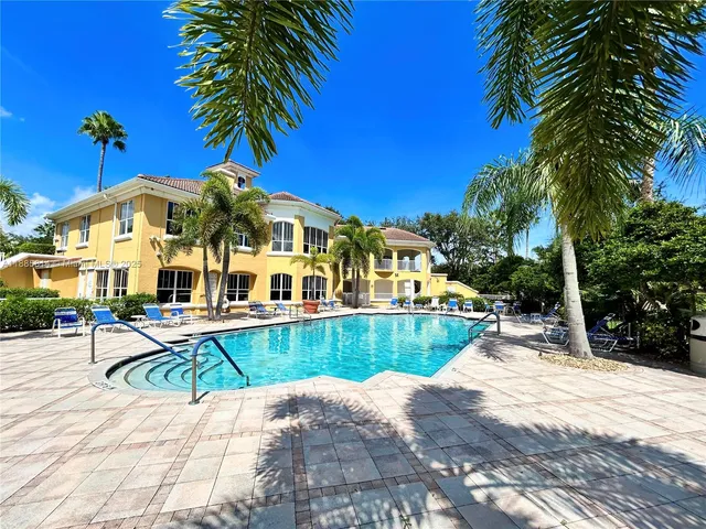 a swimming pool with potted plants and large trees